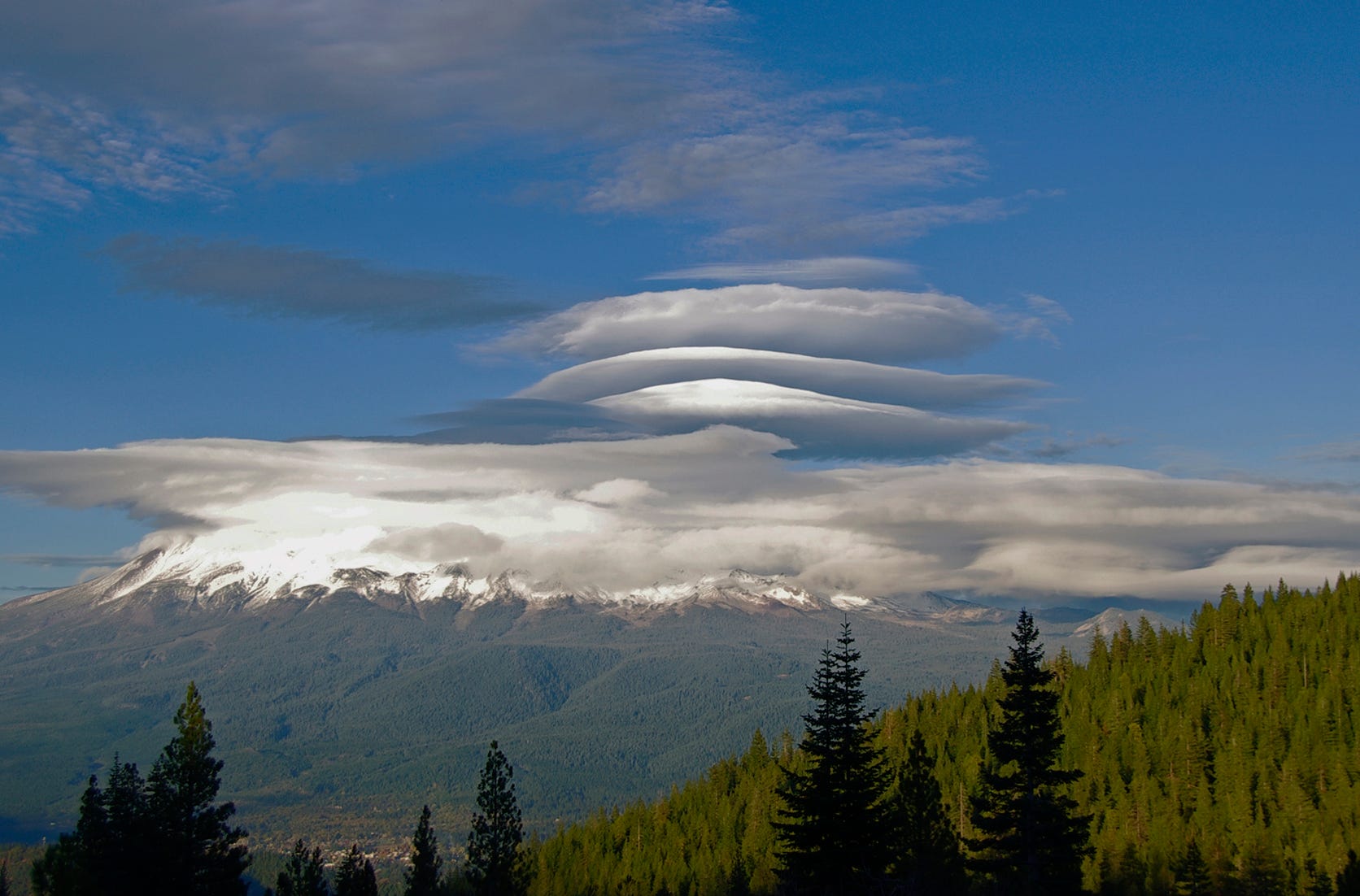 Many-stacked lenticulars hover over Mt. Shasta.